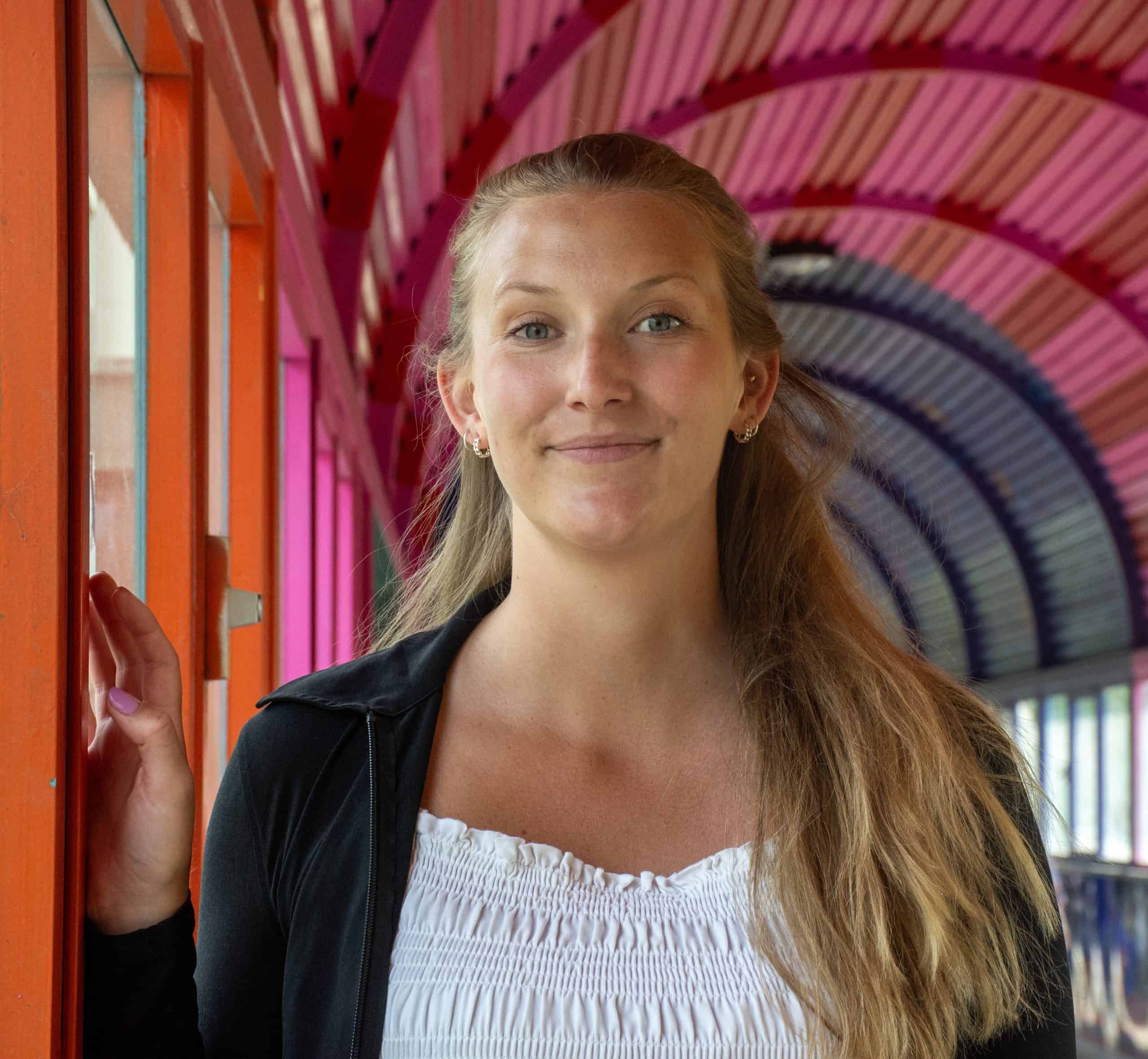 Ottilia Liljeberg, processledare, i färgglad gångbro med trädetaljer.