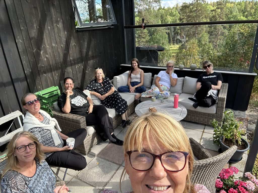 Grupp av personer som sitter på en terrass med utsikt över naturen.