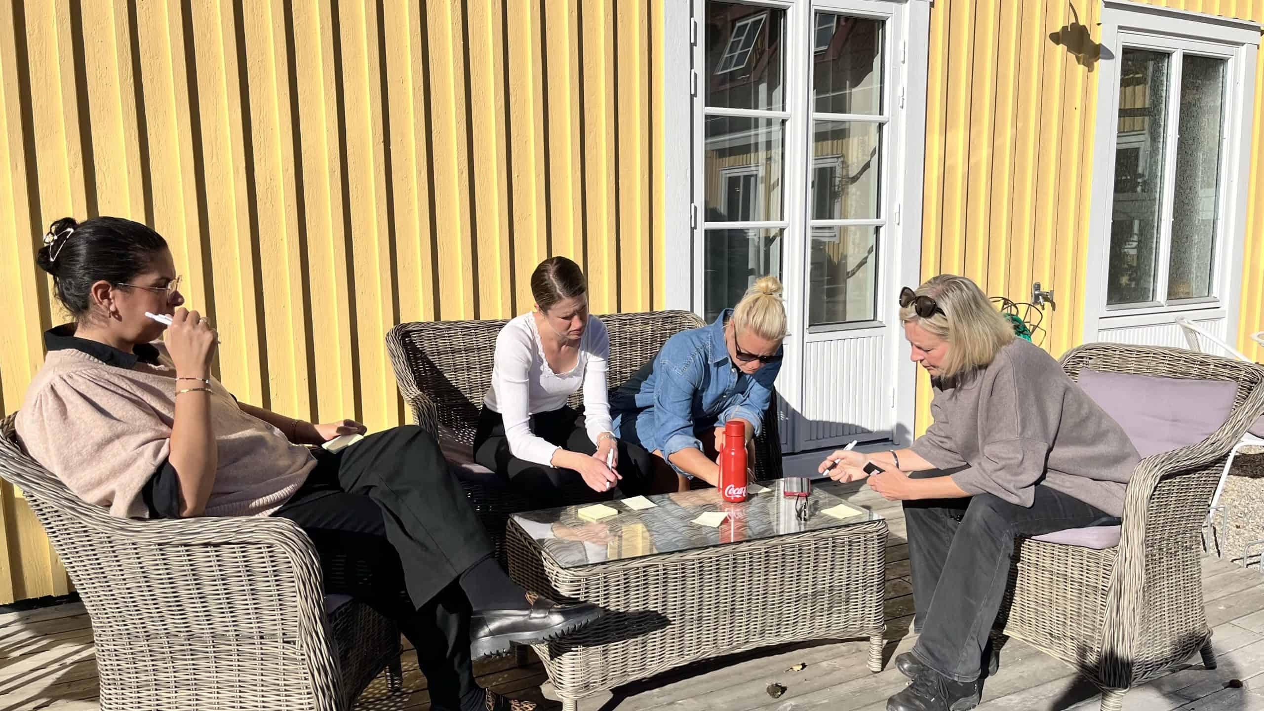 Grupp av personer som diskuterar utomhus på en solig dag.